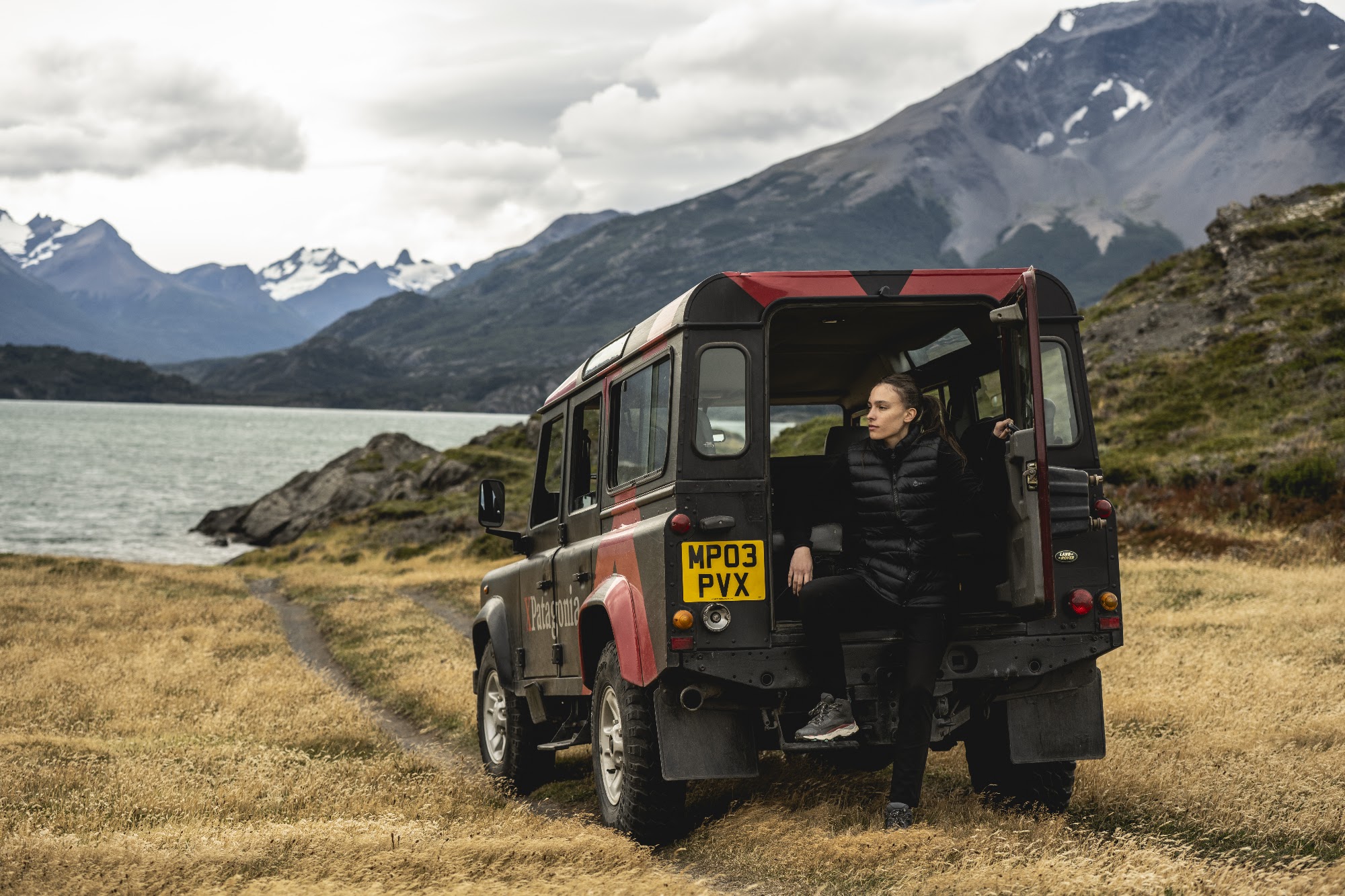 Guest stepping out of the 4×4 beside a glacial lake at Estancia La Península